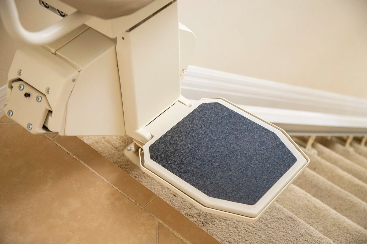 Footrest of a Harmar SL600 HD stair lift above carpeted steps