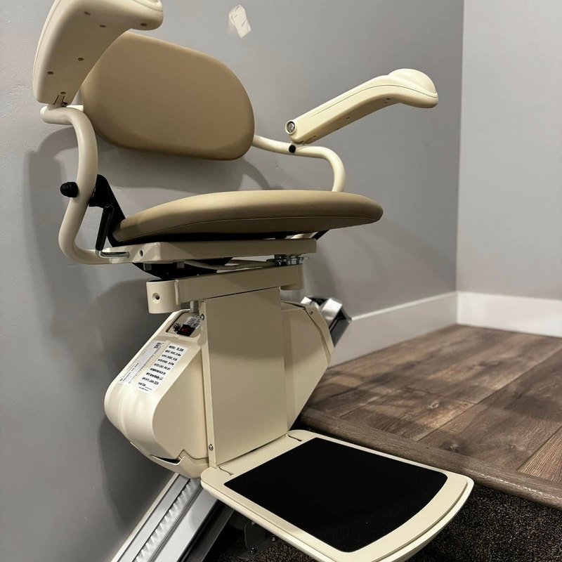 Harmar SL600 stair lift parked at the top of a carpeted staircase