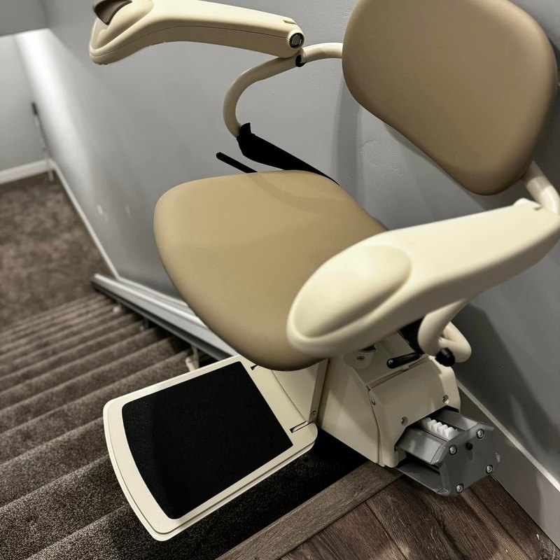 Harmar SL600 stair lift ready at the bottom of a carpeted staircase