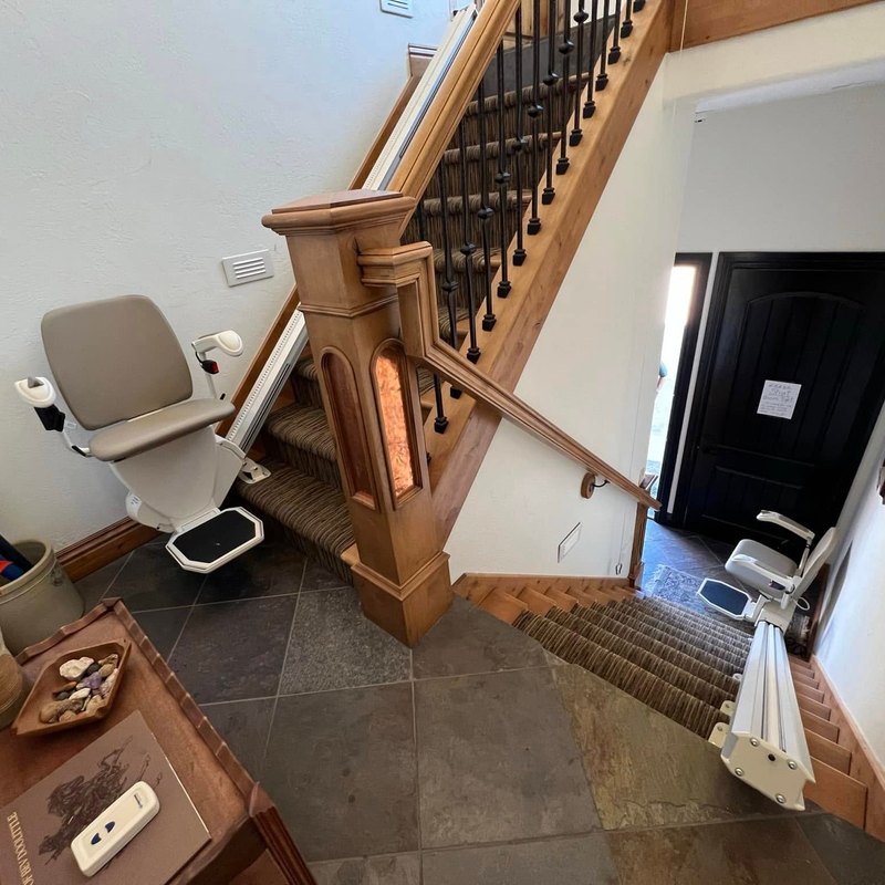 Two stair lifts in an entry hall, one on each flight of stairs