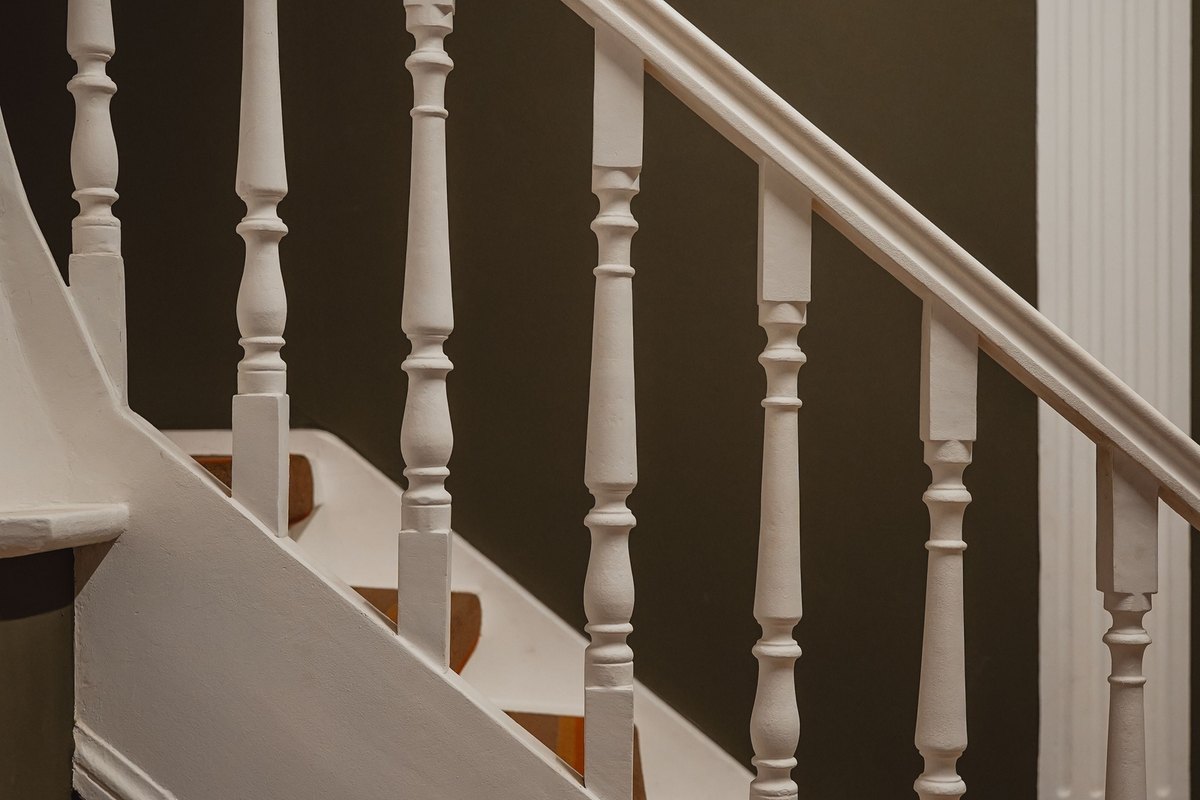 White painted banister and balusters along a straight staircase